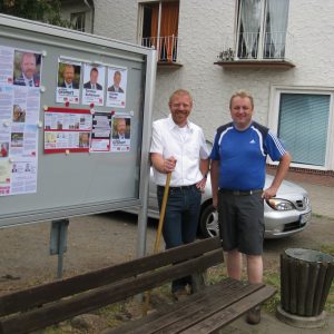 Zwei Kandidaten vor dem Schaukasten.