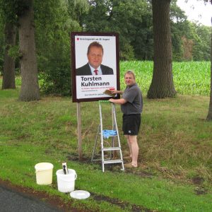 Torsten Kuhlmann klebt hier das erste Torsten Kuhlmann Plakat.