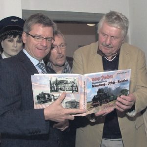 Fasziniert werfen Samtgemeindebürgermeister Reinhard Schmale und die Museumseisenbahner Bernd von Mitzlaff und Wilfried Wagenfeld gemeinsam mit Autor Günter Mootz (2.v.r.) einen Blick in die druckfrische Chronik der Eisenbahnstrecke Nienburg-Uchte-Rahden.